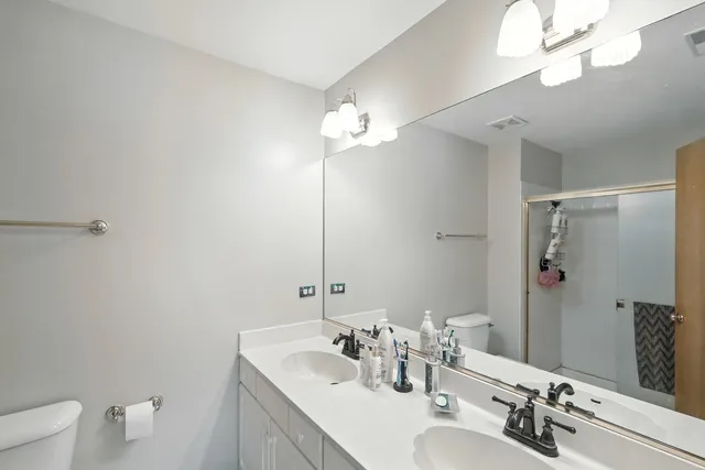 a bathroom with a sink a toilet and a mirror