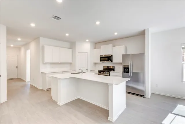 a kitchen with stainless steel appliances a sink stove and refrigerator
