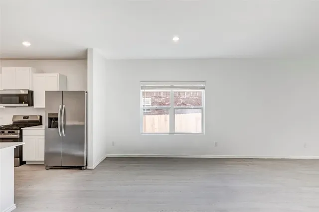 a view of a kitchen with a sink refrigerator and window