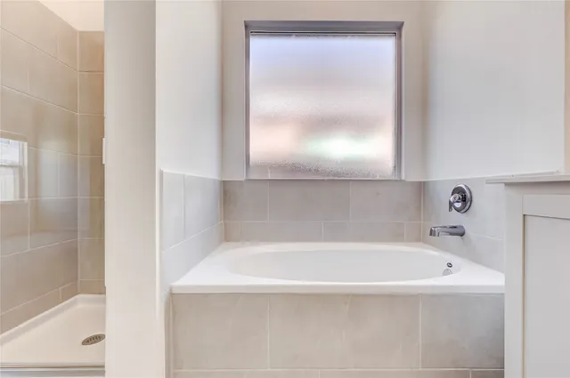 a white bath tub sitting next to a shower
