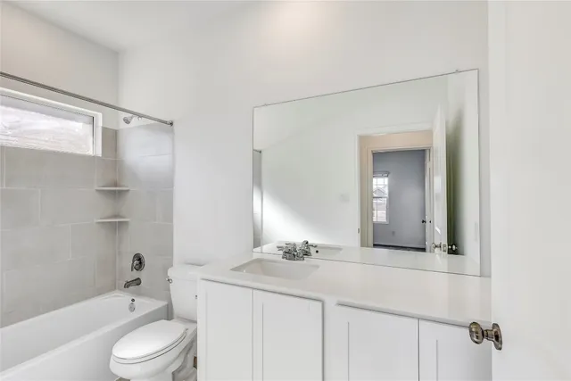 a bathroom with a granite countertop sink toilet a mirror and bathtub