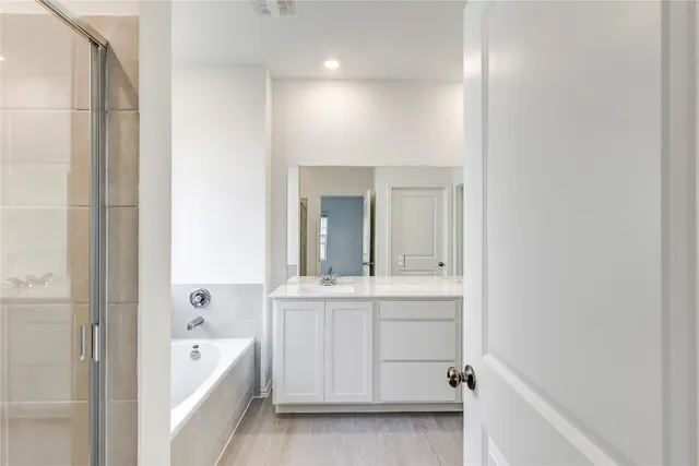 a bathroom with a tub sink and mirror