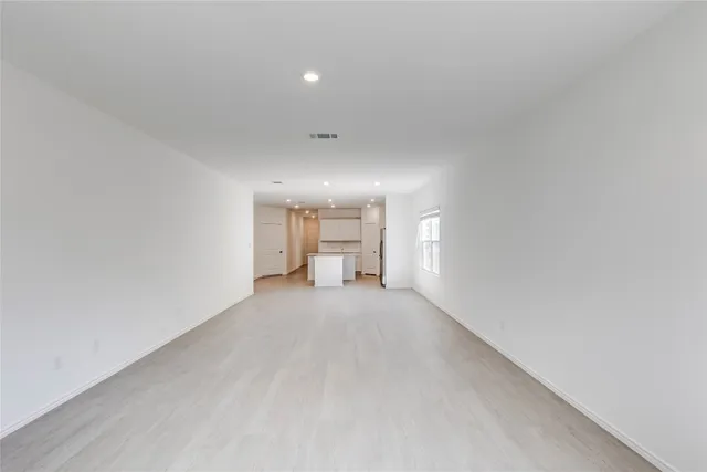 a view of a big room with windows and chandelier fan
