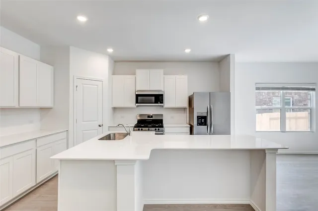 a kitchen with stainless steel appliances a refrigerator sink and microwave
