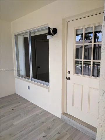 a view of an empty room with wooden floor and closet