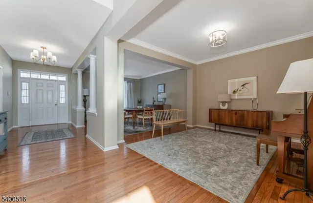 a room with lots of wooden furniture and view of living room