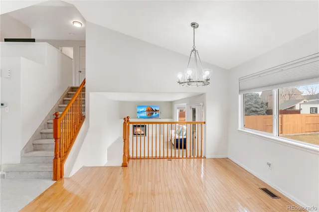 a view of a hallway with wooden floor and stairs