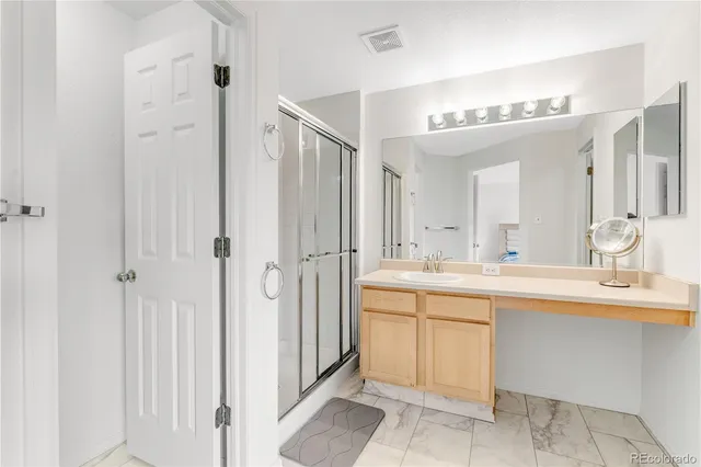 a spacious bathroom with a mirror sink and shower