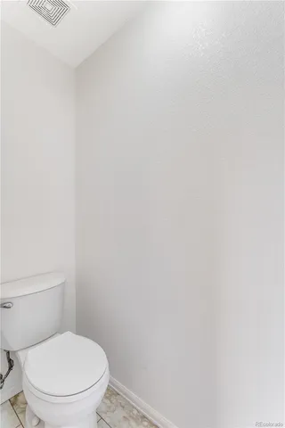 a white toilet sitting next to a white wall