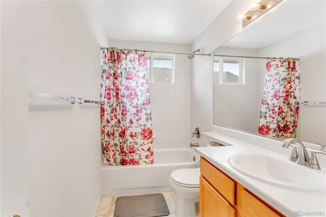 a bathroom with a sink a toilet and shower curtain
