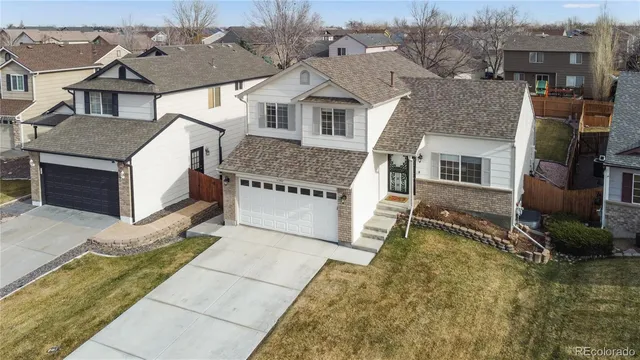 a view of a white house next to a yard with road