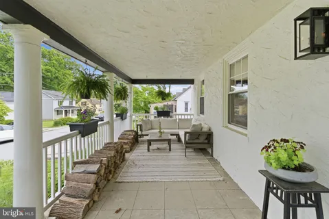a living room with patio furniture and a potted plant