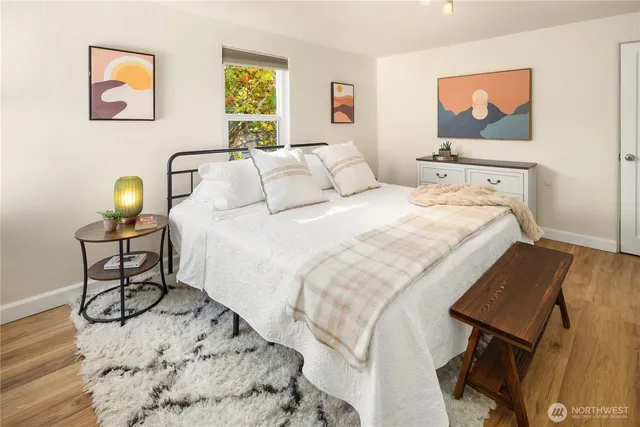 a bedroom with bed and painting on the wall