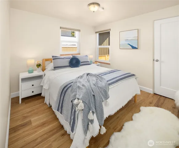 a bedroom with a bed and wooden floor