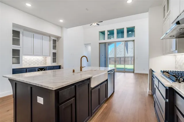 a kitchen that has a sink a stove and a wooden floor