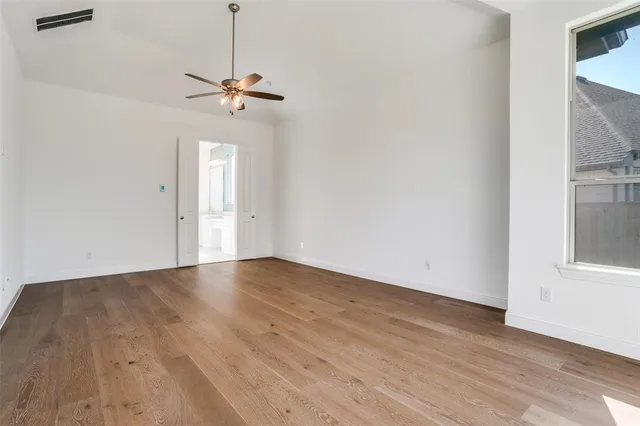a view of a room with wooden floor and ceiling fan