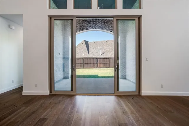 a view of a livingroom with wooden floor and a fireplace