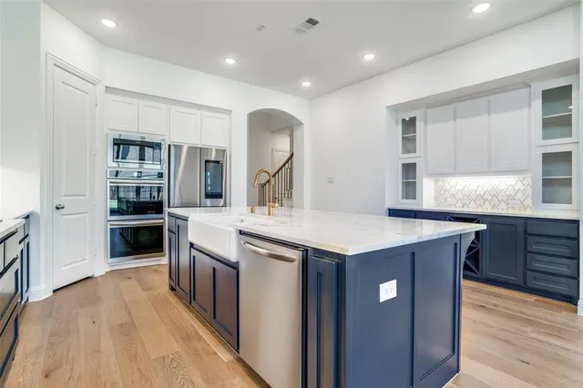 a kitchen with kitchen island a counter top space a sink and appliances