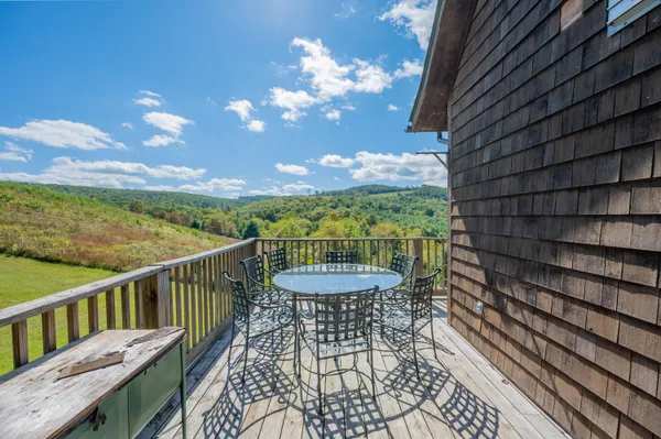 a view of a balcony with a table & chairs
