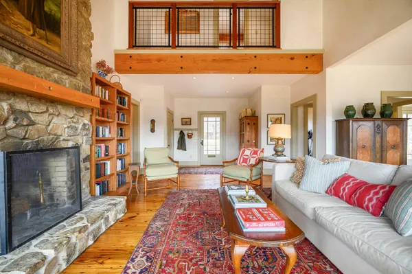 a living room with furniture a fireplace and large windows