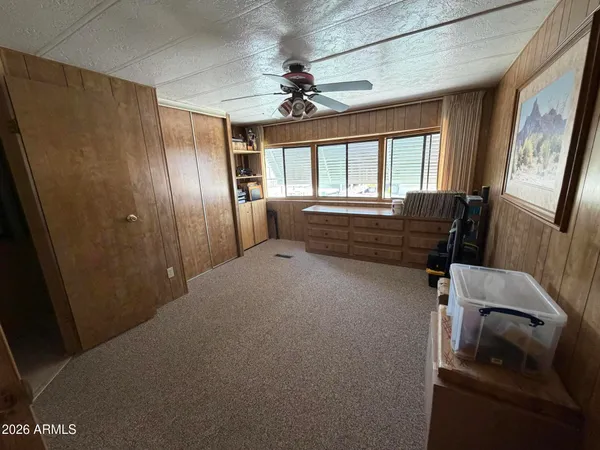 a view of hallway with windows and a ceiling fan