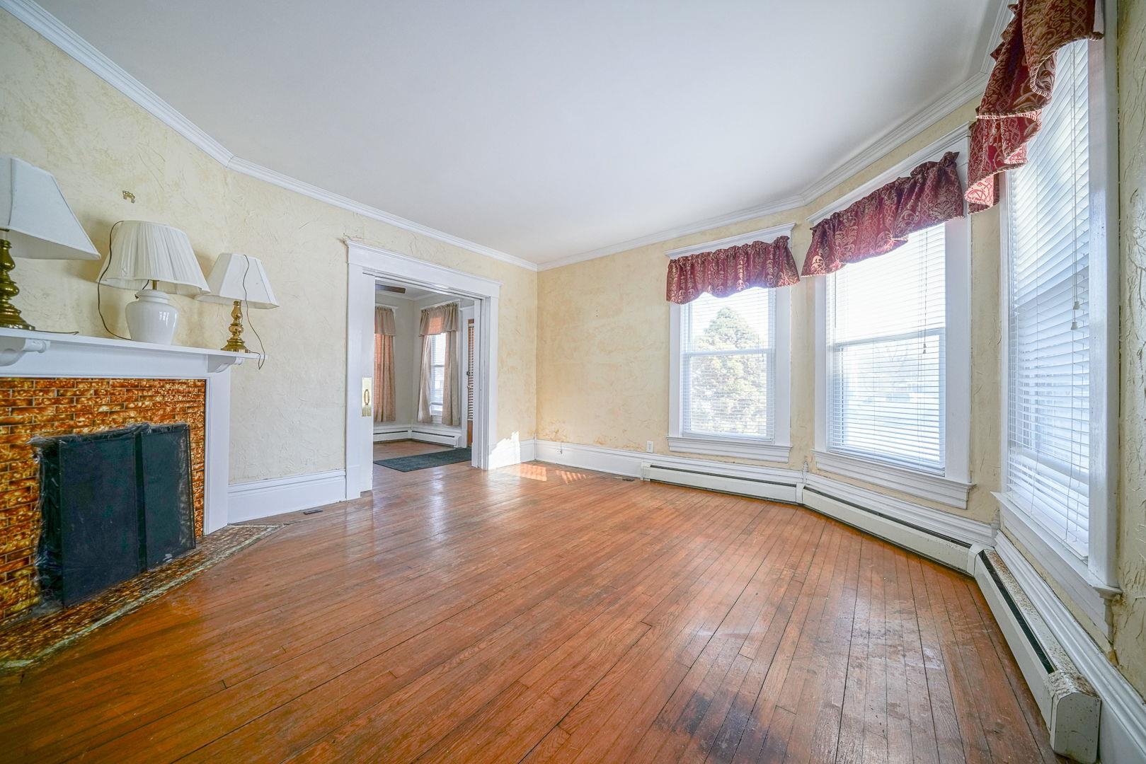 408 South 5th Street Oregon, IL 61061 - Photo 43 of 43 a view of an empty room with wooden floor fireplace and a window