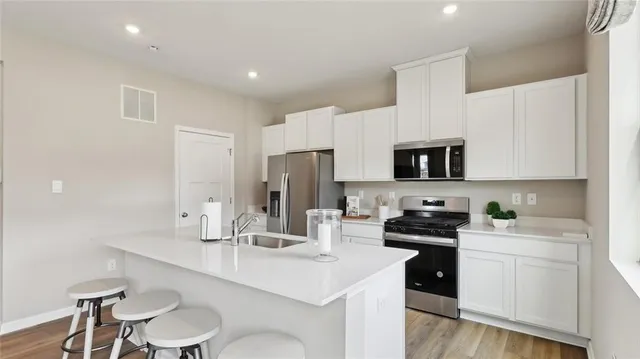 a kitchen with stainless steel appliances a refrigerator sink and stove