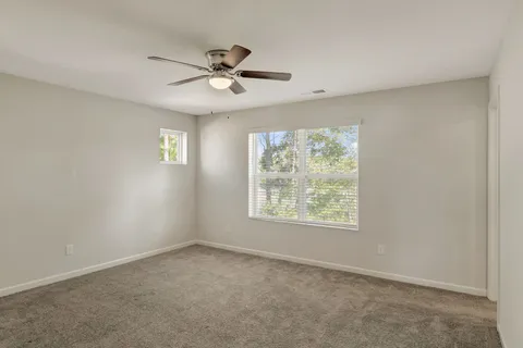 an empty room with a window and a fan