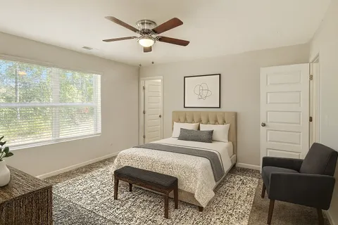 a bedroom with a bed a couch and a window