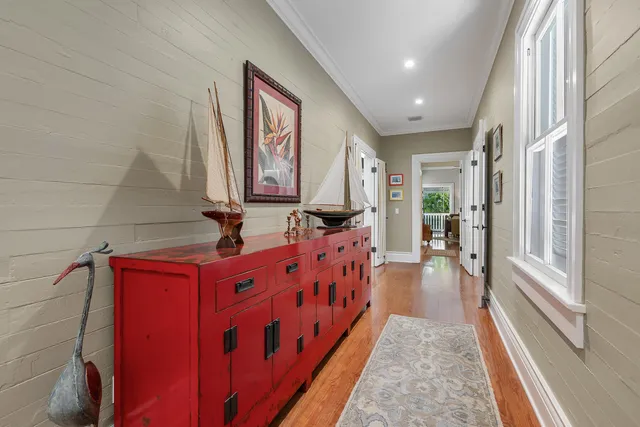 a hallway with beautiful frames on wall and wooden floor