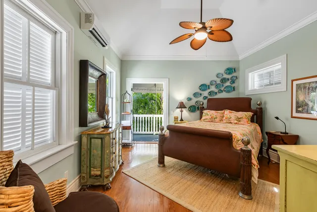 a bedroom with a bed ceiling fan and a window