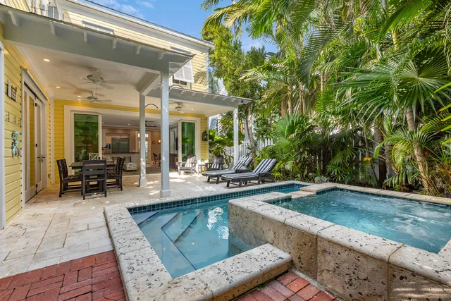 a balcony with chairs and with potted plants