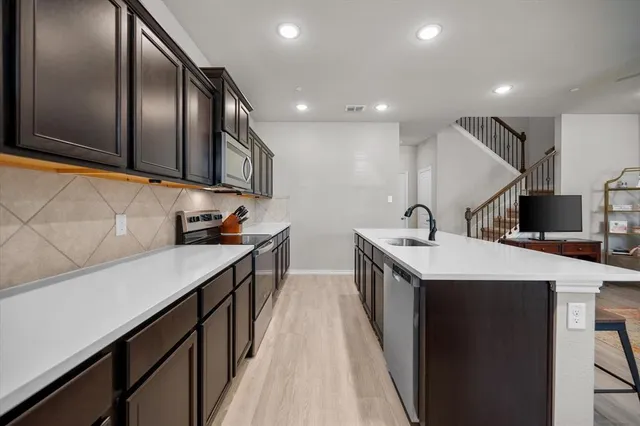 a kitchen with stainless steel appliances granite countertop a sink and stove