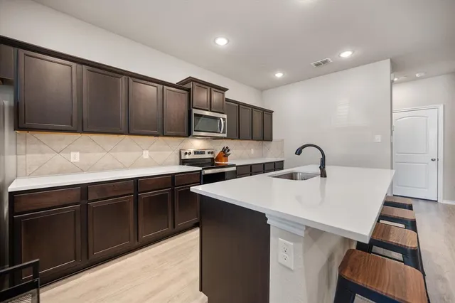a kitchen with kitchen island granite countertop a sink stove and refrigerator