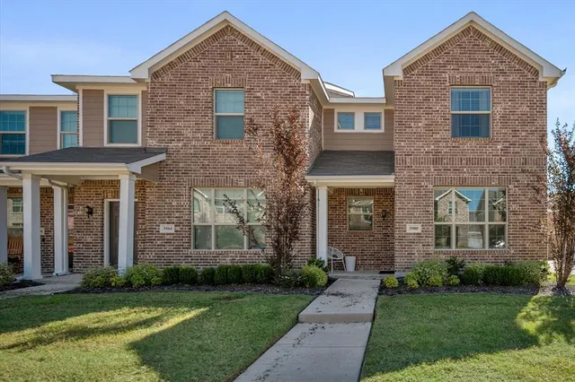 front view of a brick house with a yard