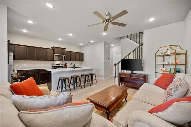 a living room with furniture kitchen view and a flat screen tv