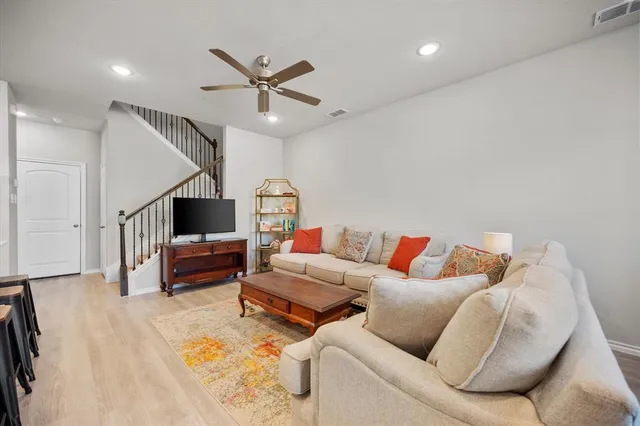 a living room with furniture and a wooden floor