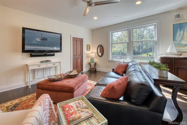 a living room with furniture a flat screen tv and a large window