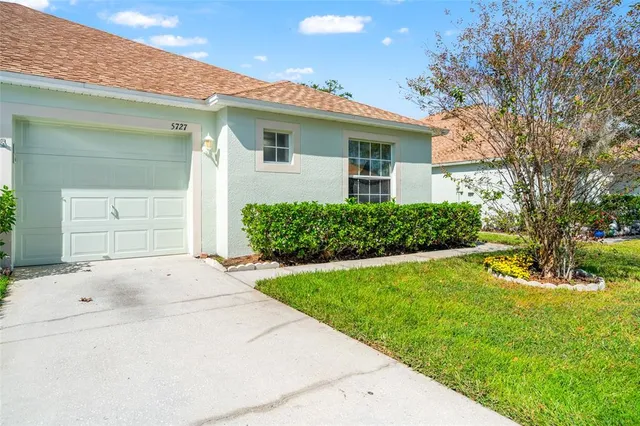 a kitchen with stainless steel appliances granite countertop a refrigerator a stove a sink dishwasher and wooden cabinets with wooden floor