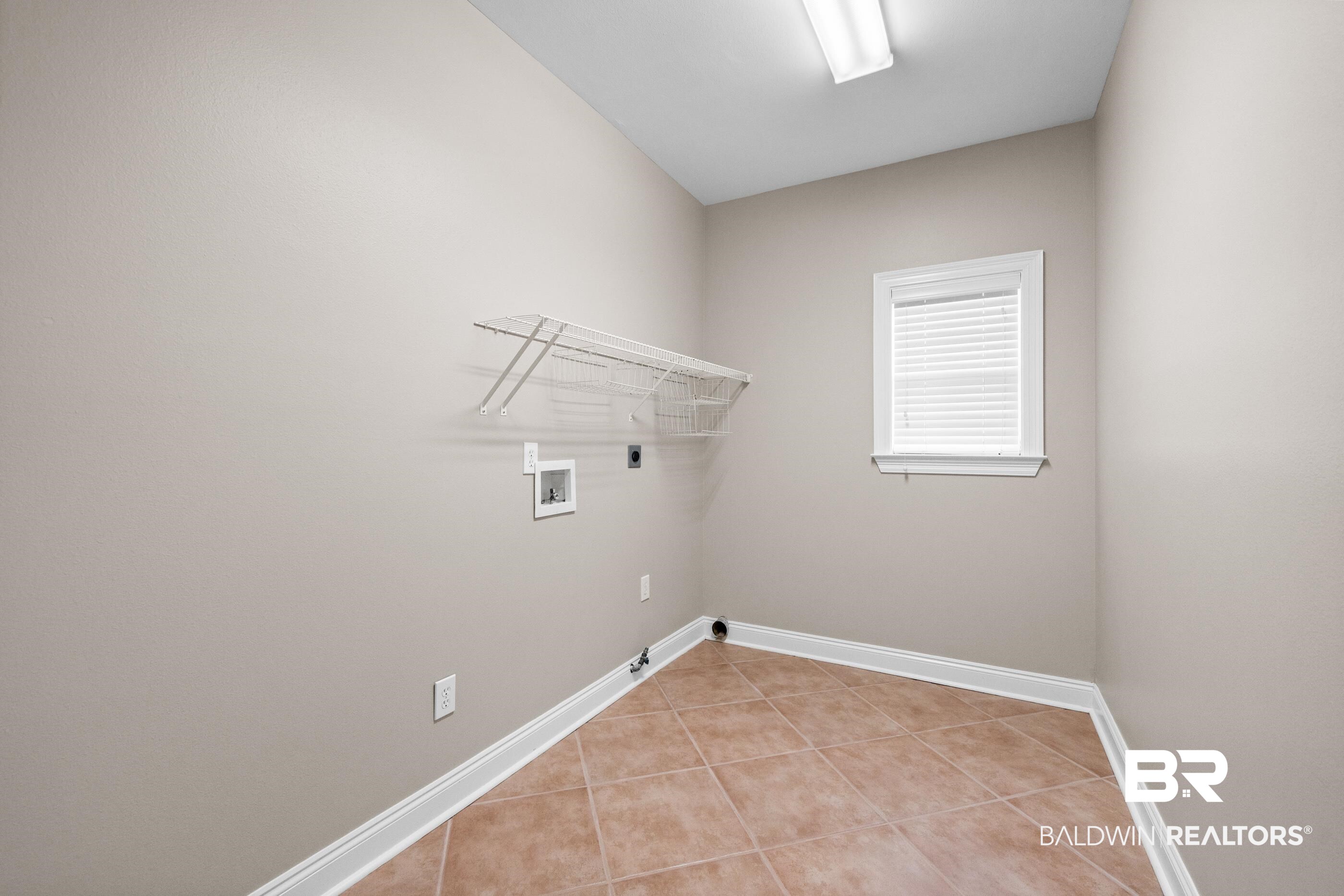 303 Savannah Circle Foley, AL 36535 - Photo 18 of 34 Utility room featuring ceramic tile flooring, a window with blinds, and a built-in wire shelf