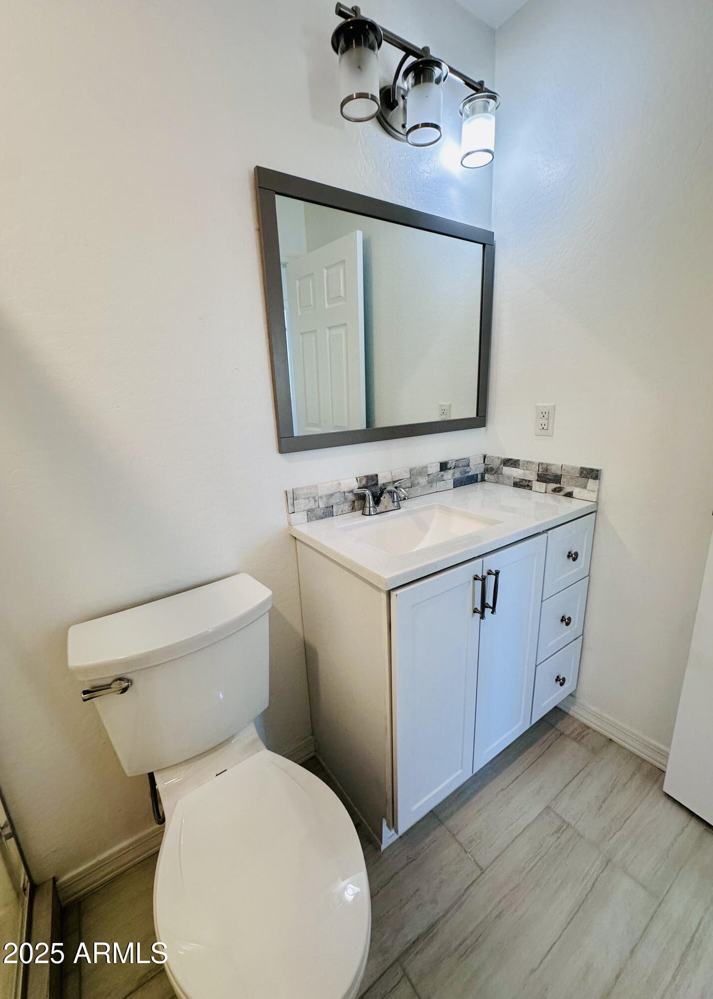32007 North Bush Street Wittmann, AZ 85361 - Photo 12 of 22 a bathroom with a toilet sink and mirror