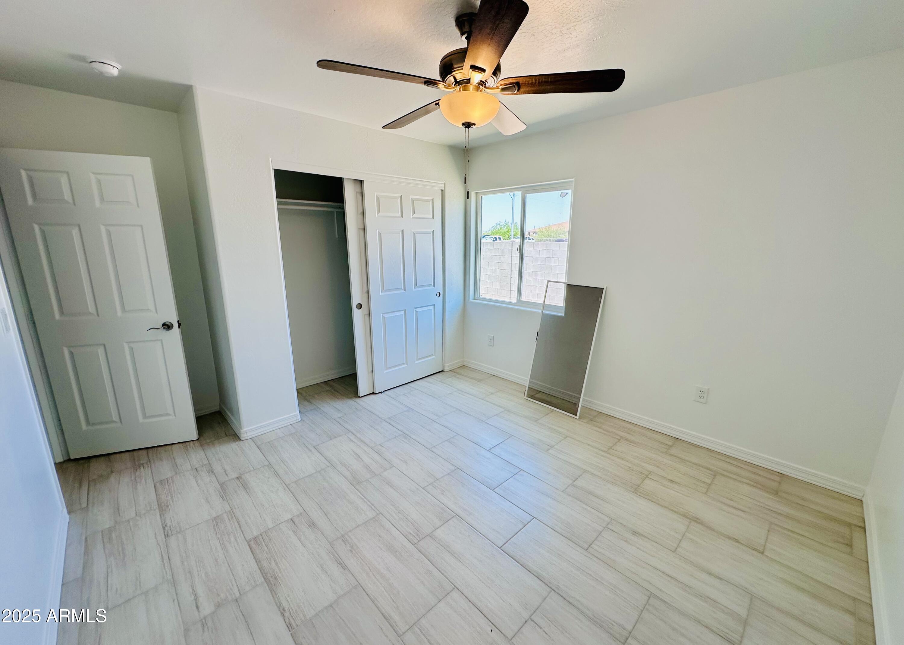 32007 North Bush Street Wittmann, AZ 85361 - Photo 13 of 22 an empty room with wooden floor and windows
