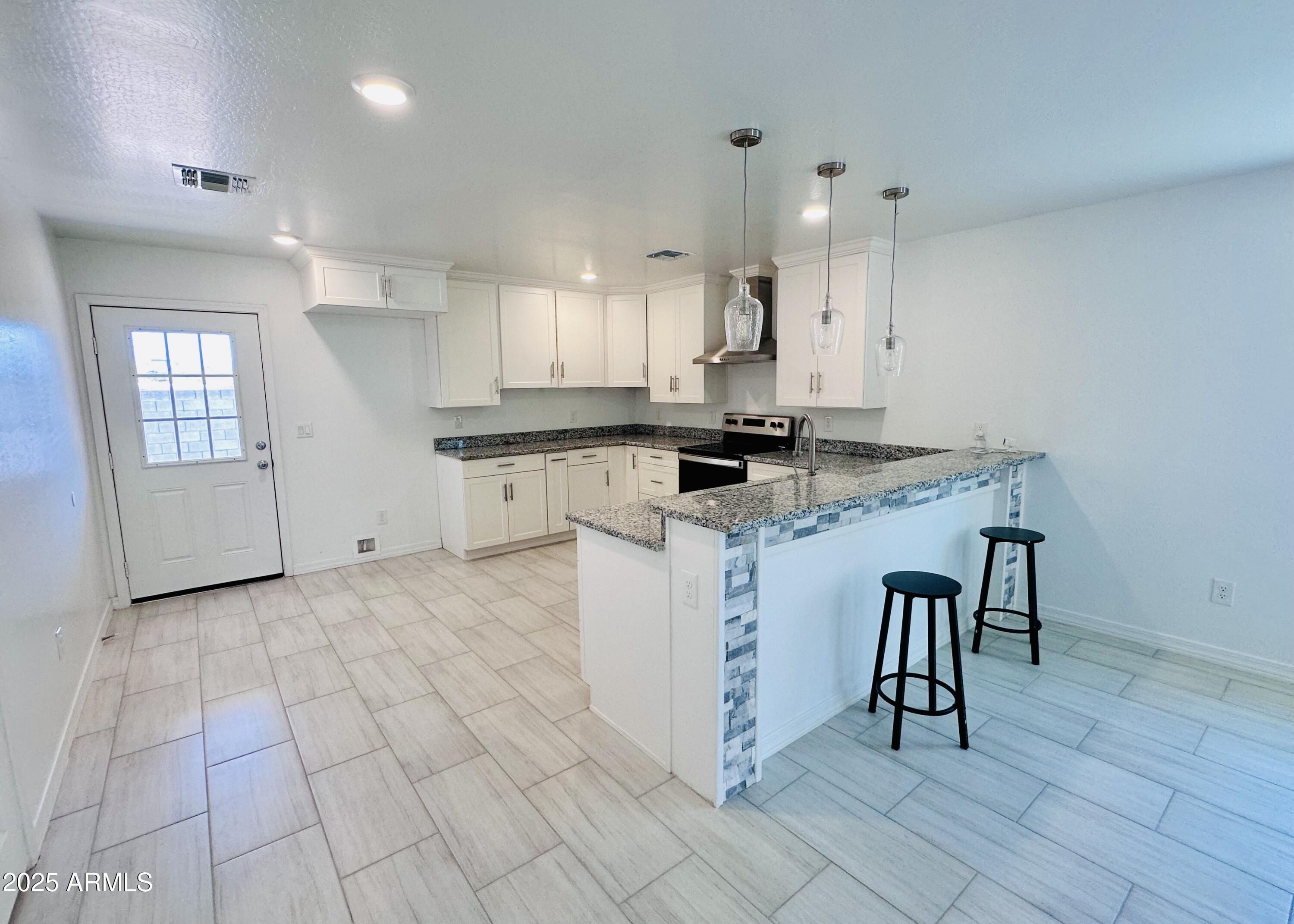 32007 North Bush Street Wittmann, AZ 85361 - Photo 6 of 22 a kitchen with a stove a sink cabinets and dining table