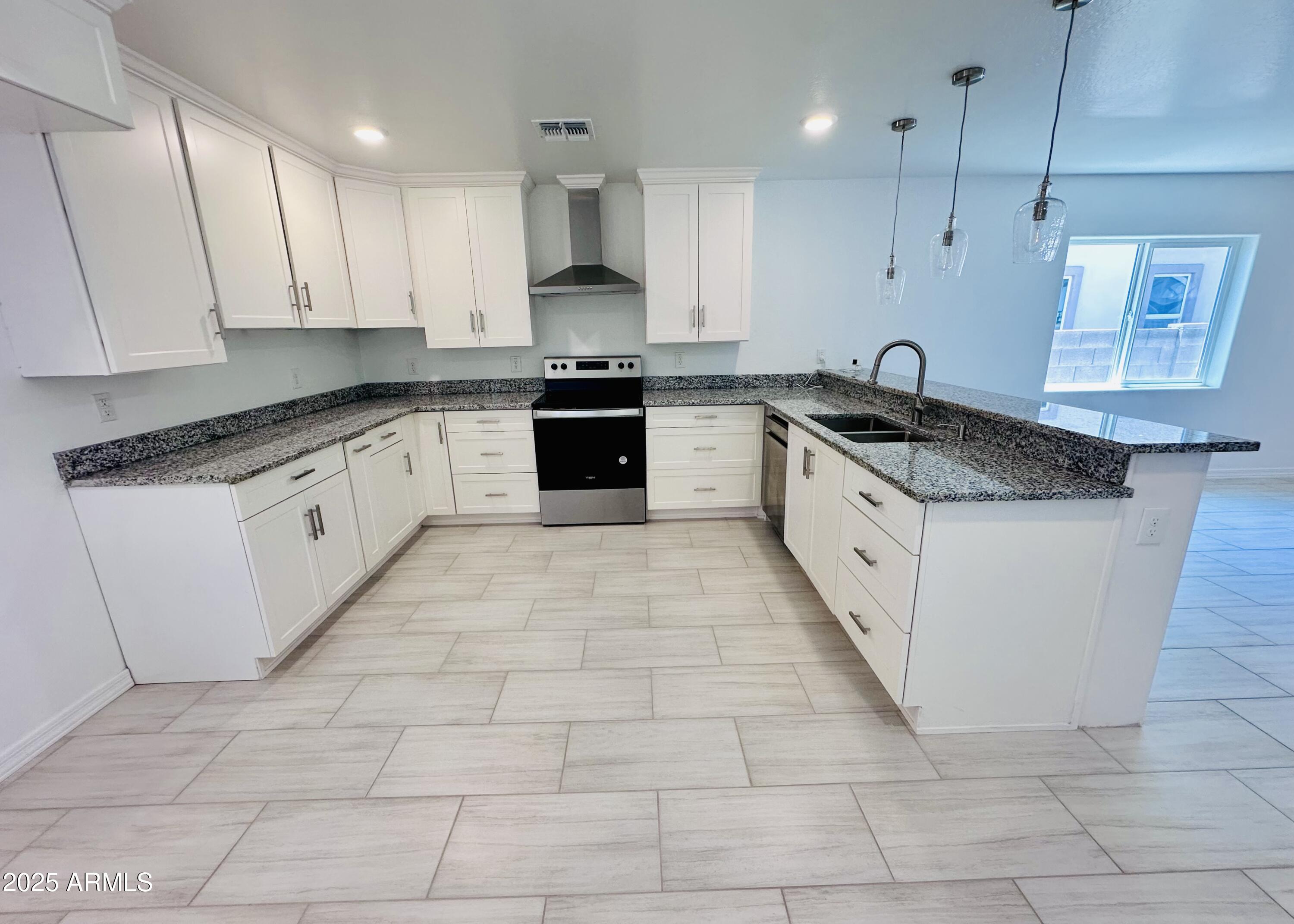 32007 North Bush Street Wittmann, AZ 85361 - Photo 7 of 22 a large kitchen with granite countertop a sink a counter top space appliances and cabinets