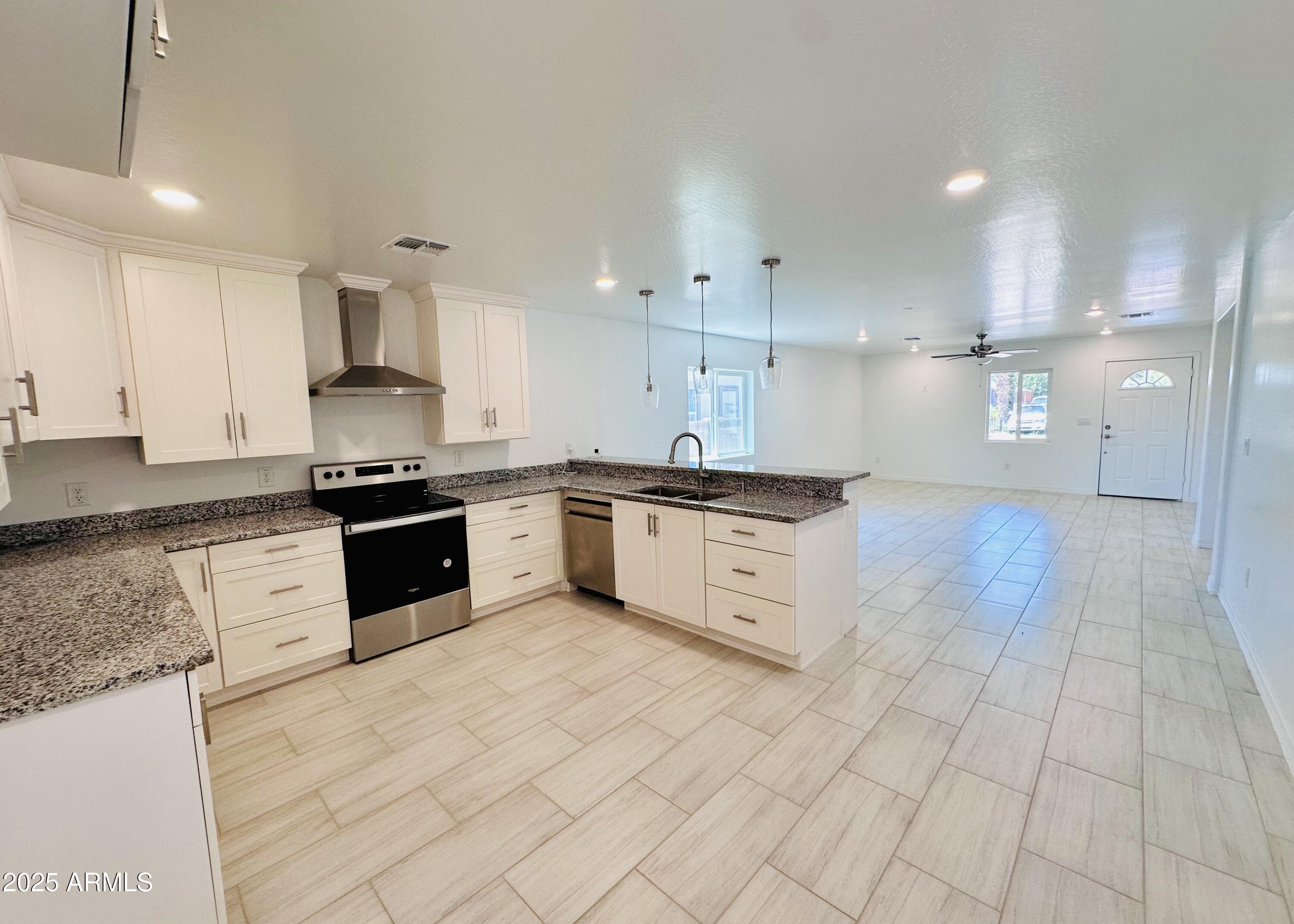 32007 North Bush Street Wittmann, AZ 85361 - Photo 8 of 22 a large kitchen with granite countertop a stove top oven a sink a counter space and cabinets