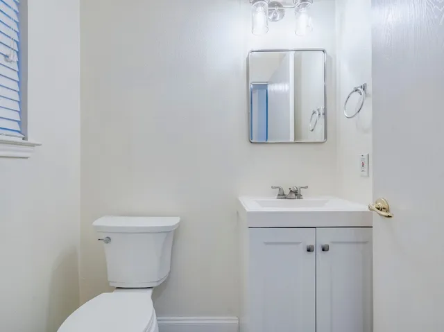 a bathroom with a toilet sink and mirror