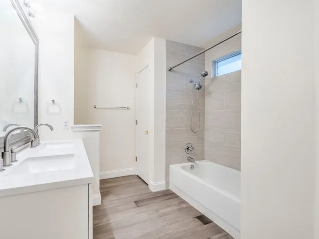 a bathroom with a tub sink and mirror