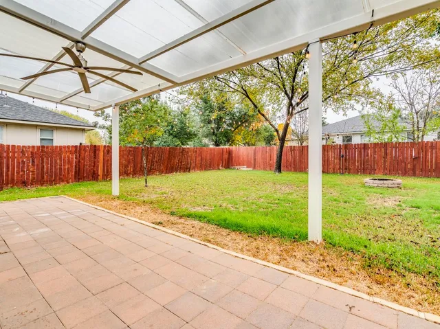 a view of a backyard with table and chairs under an umbrella