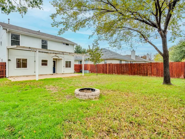 a view of a house with backyard and a tree