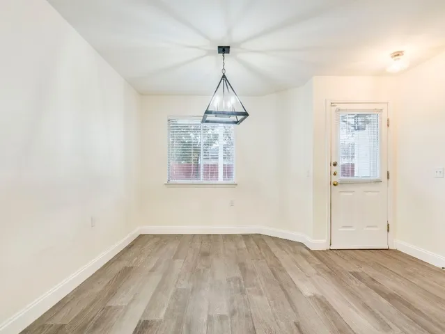 a view of a room with wooden floor closet and a window